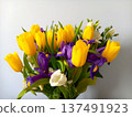 Colorful spring bouquet of yellow tulips, violet irises and white eustoma on a soft blue background 137491923