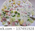 Close-up of traditional Russian cold soup okroshka with kefir, cucumbers, sausage, potatoes, and fresh parsley 137491928