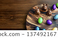 Chocolate bunnies and colorful eggs arranged on wooden platter with copy space 137492167
