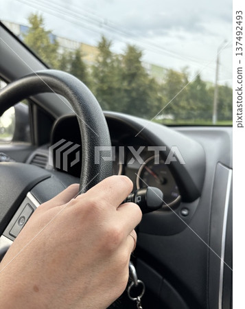 close-up of a male driver's hand on the steering wheel of a car close-up of a male driver's hand on the steering wheel of a car 137492493