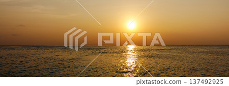 Banner with copy space. Golden sun dips low over calm sea waters Banner with copy space. Golden sun dips low over calm sea waters 137492925