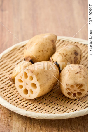 Raw lotus root (renkon) ingredients served on a bamboo colander Raw lotus root (renkon) ingredients served on a bamboo colander 137492947