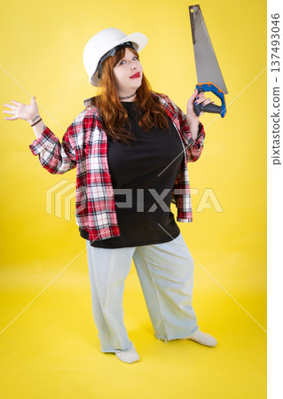Woman builder holding handsaw and shrugging gesture 137493046