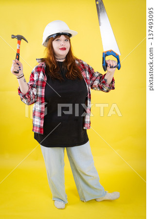 Building woman holding hammer and saw 137493095