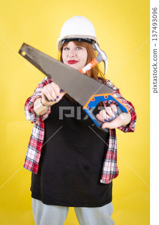 Woman worker presenting saw and hammer for building project Woman worker presenting saw and hammer for building project 137493096