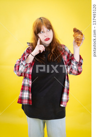 Young woman contemplating croissant food choice dilemma Young woman contemplating croissant food choice dilemma 137493120