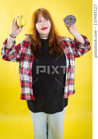 Young woman choosing between healthy apple and unhealthy donut 137493127