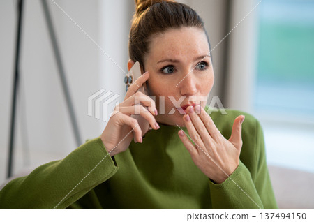 Waist up of a young woman talking on the phone and looking shocked Waist up of a young woman talking on the phone and looking shocked 137494150