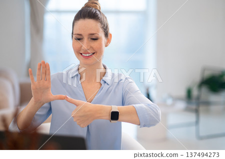 Smiling cute young woman explaining something on video call by sign language 137494273