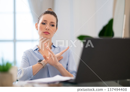 Young business woman finishing the video call with close gesture Young business woman finishing the video call with close gesture 137494408