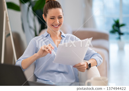 Young professional working with documents and looking confident Young professional working with documents and looking confident 137494422