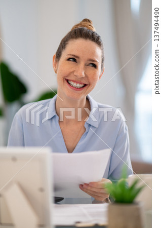 Young business woman looking busy while working from her home office Young business woman looking busy while working from her home office 137494490