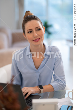 Young business woman looking busy while working from her home office 137494544