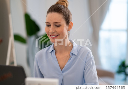 Young business woman looking busy while working from her home office 137494565