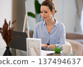 Young business woman looking busy while working from her home office 137494637