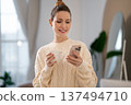 Cute caucasian woman in white sweater with a cup in hands 137494710