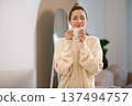 Cute caucasian woman in white sweater with a cup in hands 137494757