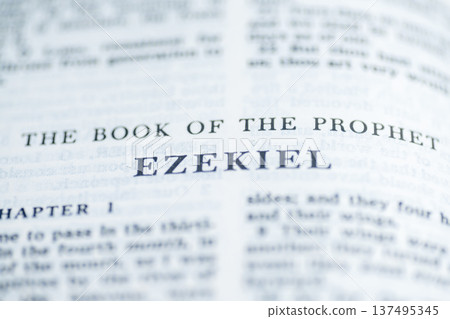 A macro shot of the title page for the Book of Ezekiel in a Holy Bible, featuring sharp black typography with a shallow depth of field on a clean white page A macro shot of the title page for the Book of Ezekiel in a Holy Bible, featuring sharp black typography with a shallow depth of field on a clean white page 137495345