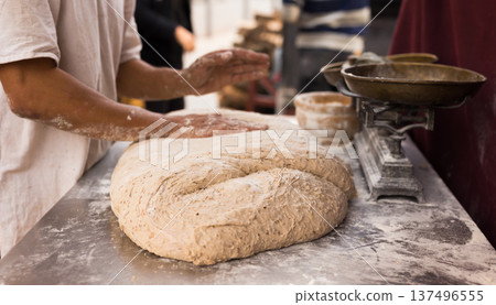 male hands knead yeast dough for baking bread male hands knead yeast dough for baking bread 137496555
