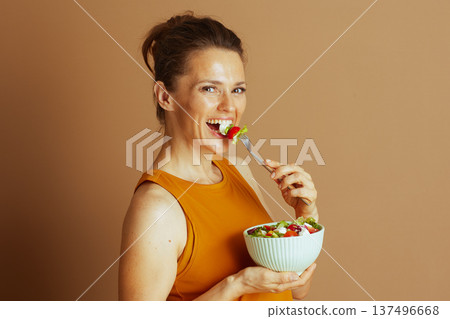 Happy Woman Savors a Fresh Green Salad Happy Woman Savors a Fresh Green Salad 137496668