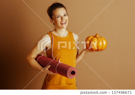 Autumn Yoga: Woman with Pumpkin and Mat Autumn Yoga: Woman with Pumpkin and Mat 137496671