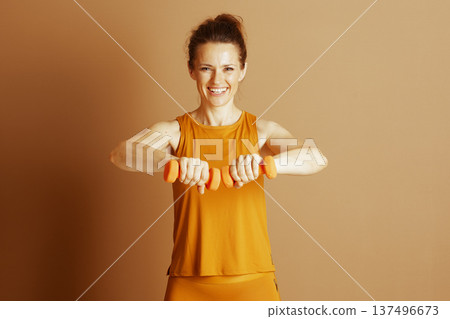 Cheerful Woman with Dumbbells Ready for Workout Cheerful Woman with Dumbbells Ready for Workout 137496673