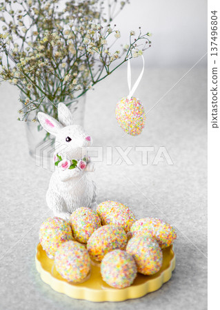 Easter bunny figurine with pastel decorated eggs and spring flowers on kitchen counter 137496804
