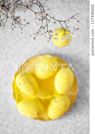 Yellow Easter eggs in pastel bowl with delicate baby s breath for spring table decor 137496808