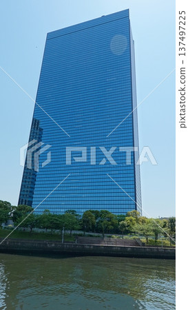 Glass-walled skyscrapers shining against the blue sky Glass-walled skyscrapers shining against the blue sky 137497225