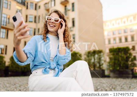Beautiful woman traveler using phone, taking selfie, walking on the old town street. Blogging Beautiful woman traveler using phone, taking selfie, walking on the old town street. Blogging 137497572