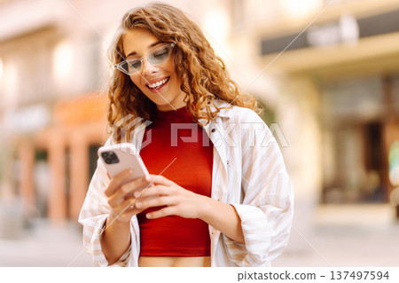 Happy woman tourist with phone. Young woman writing text for sharing content about vacations Happy woman tourist with phone. Young woman writing text for sharing content about vacations 137497594