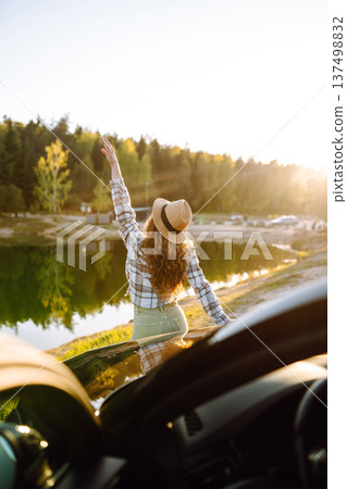 Young woman enjoying and having fun in their vacations outdoors leaning out car window. Summer trip. Young woman enjoying and having fun in their vacations outdoors leaning out car window. Summer trip. 137498832