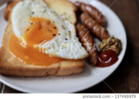 Toast topped with crumbled soft-boiled eggs and coarsely ground sausages Toast topped with crumbled soft-boiled eggs and coarsely ground sausages 137498979