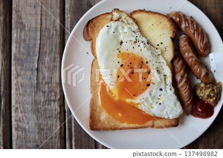 Toast topped with crumbled soft-boiled eggs and coarsely ground sausages Toast topped with crumbled soft-boiled eggs and coarsely ground sausages 137498982