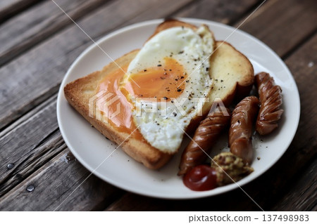 Toast topped with crumbled soft-boiled eggs and coarsely ground sausages 137498983