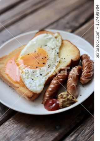 Toast topped with crumbled soft-boiled eggs and coarsely ground sausages 137498984