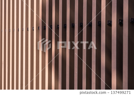 Dark brown slat panel exterior wall and light and shadow texture background Dark brown slat panel exterior wall and light and shadow texture background 137499271