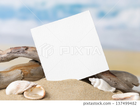 Mockup of blank card on beige sand with seashells, template for beach wedding and event graphics 137499482