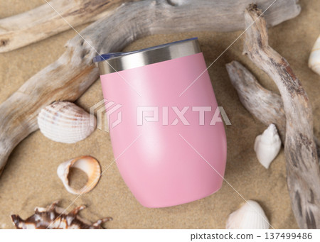 Wine tumbler mockup with blank white 12oz stainless steel cup on sand with seashells and driftwood Wine tumbler mockup with blank white 12oz stainless steel cup on sand with seashells and driftwood 137499486