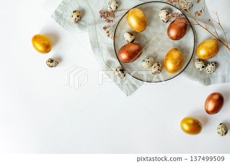 Golden and bronze Easter eggs in a grey plate 137499509