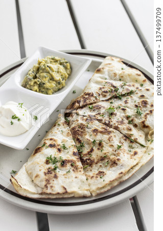 cheese quesadilla plate with guacamole and sour cream on white restaurant table in mexico cheese quesadilla plate with guacamole and sour cream on white restaurant table in mexico 137499709