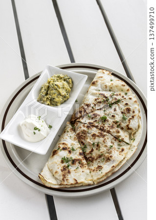 cheese quesadilla plate with guacamole and sour cream on white restaurant table in mexico cheese quesadilla plate with guacamole and sour cream on white restaurant table in mexico 137499710