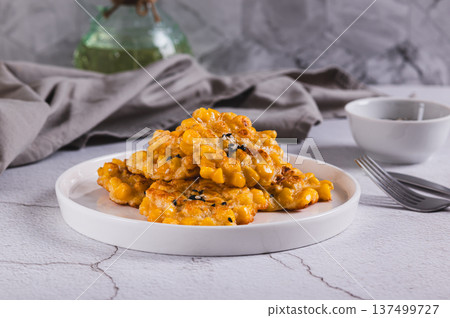 Delicious corn fritters with herbs on a plate on the table 137499727