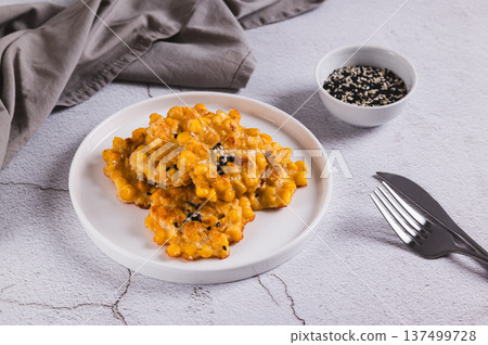 Golden crispy corn fritters on a plate on the table 137499728