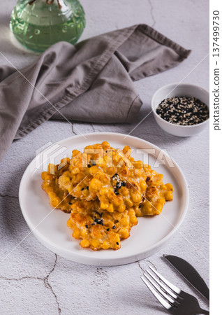 Golden crispy corn fritters on a plate on the table vertical view Golden crispy corn fritters on a plate on the table vertical view 137499730
