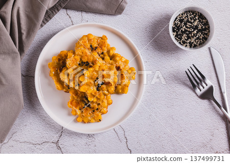 Delicious corn fritters with herbs on a plate on the table top view 137499731