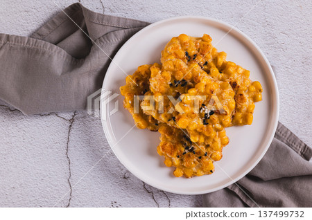Close up of delicious corn fritters with herbs on a plate on the table top view 137499732