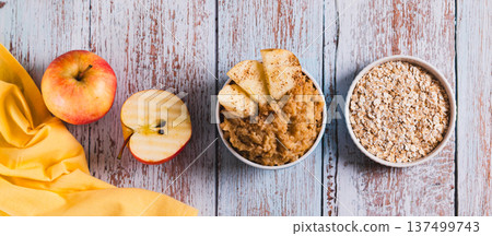 Oatmeal with apple baked in a bowl on the table top view web banner Oatmeal with apple baked in a bowl on the table top view web banner 137499743