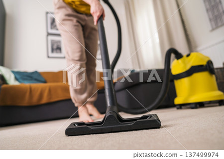 Vacuuming the floor. Close up of vacuum cleaner, living room. Household and useful technology lifestyle. Copy space Vacuuming the floor. Close up of vacuum cleaner, living room. Household and useful technology lifestyle. Copy space 137499974