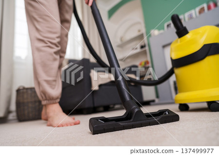 Vacuuming the floor. Close up of vacuum cleaner, living room. Household and useful technology lifestyle. Copy space Vacuuming the floor. Close up of vacuum cleaner, living room. Household and useful technology lifestyle. Copy space 137499977